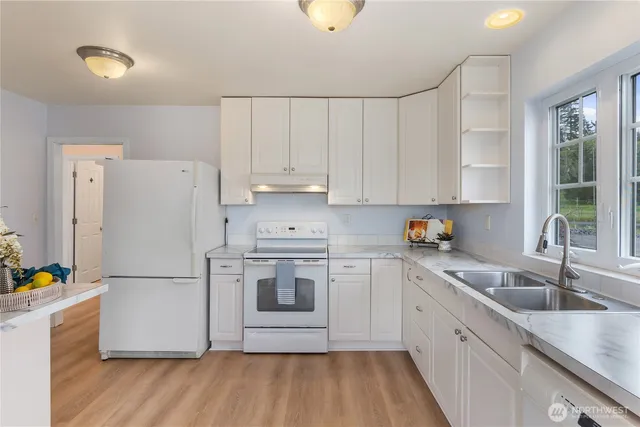 a kitchen with a refrigerator sink and cabinets