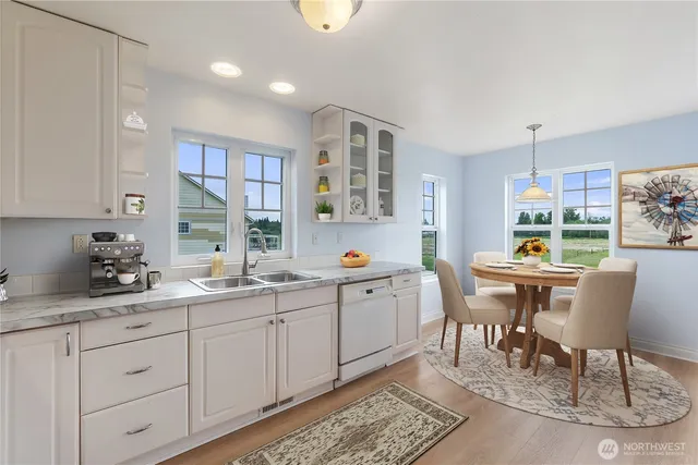 a kitchen with white cabinets and chairs