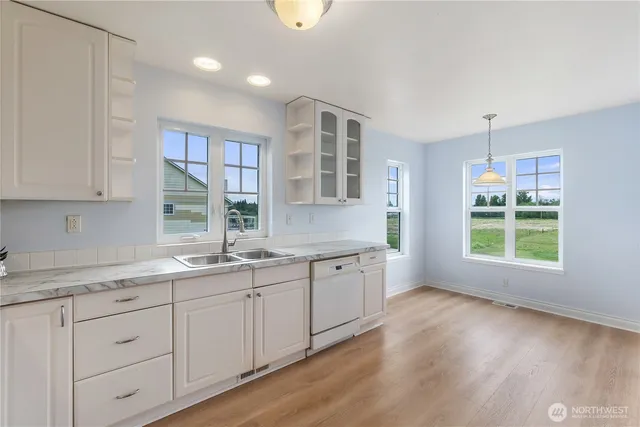 a open kitchen with granite countertop a sink and dishwasher with wooden floor