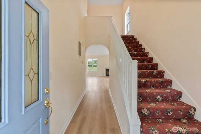 a view of a hallway with wooden floor and entryway