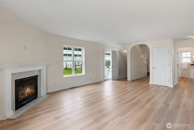 an empty room with windows and a fireplace