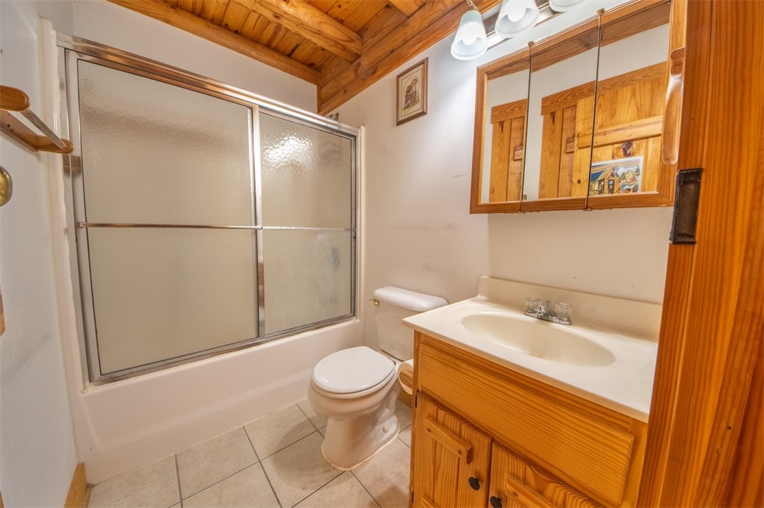 846 Twiggs Ferry Road Hartfield, VA 23071 - Photo 5 of 28 Bathroom featuring bath / shower combo with glass door, vanity, a wooden ceiling with exposed beams, and light tile patterned floors