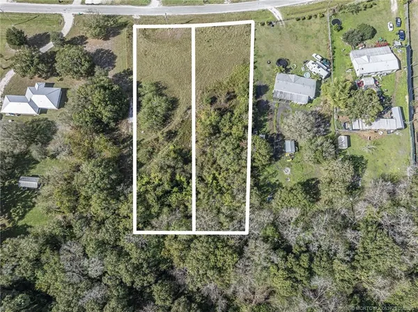 an aerial view of residential house with outdoor space and trees all around