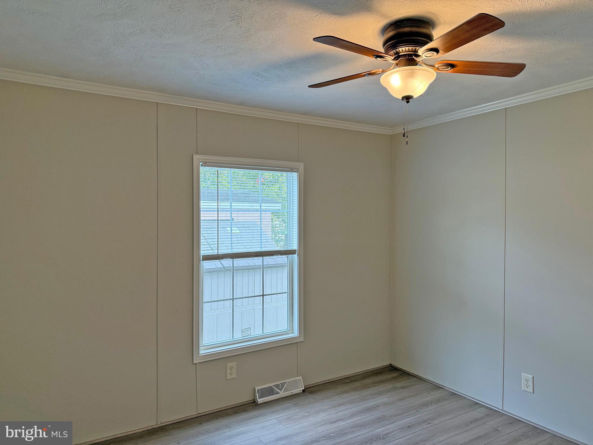 31646 Janice Road, Unit C29 Lewes, DE 19958 - Photo 19 of 34 an empty room with wooden floor closet and fan