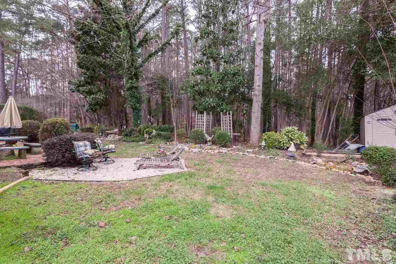 3400 Edgemont Drive Raleigh, NC 27612 - Photo 22 of 22 a view of a backyard with table and chairs and a fire pit