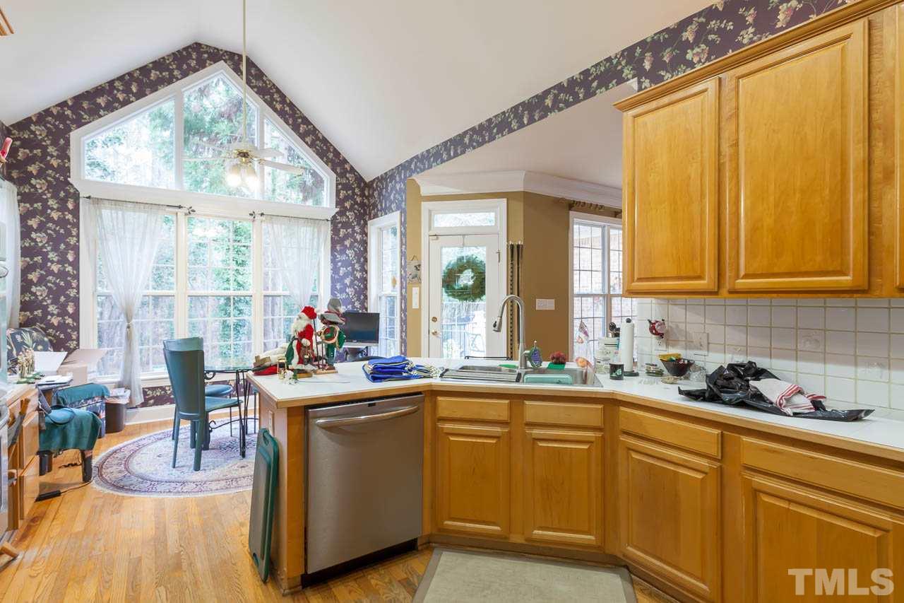 3400 Edgemont Drive Raleigh, NC 27612 - Photo 8 of 22 a kitchen with sink cabinets and wooden floor