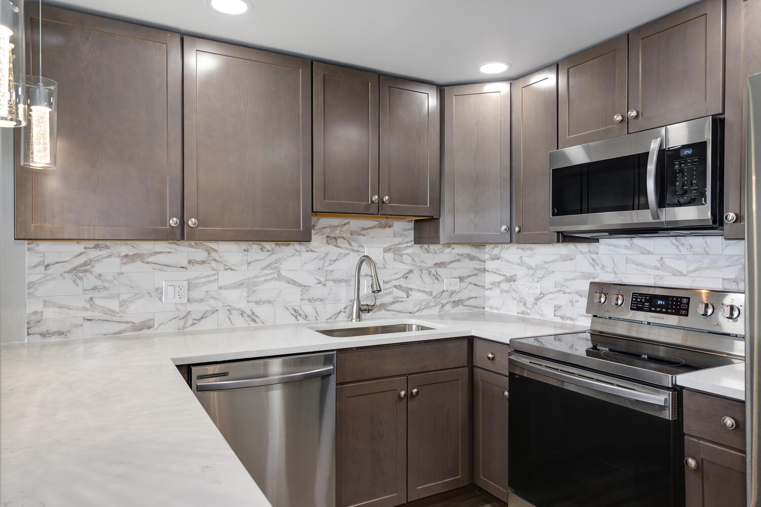 5445 North Sheridan Road, Unit 2708 Chicago, IL 60640 - Photo 4 of 16 a kitchen with stainless steel appliances granite countertop a sink stove and microwave
