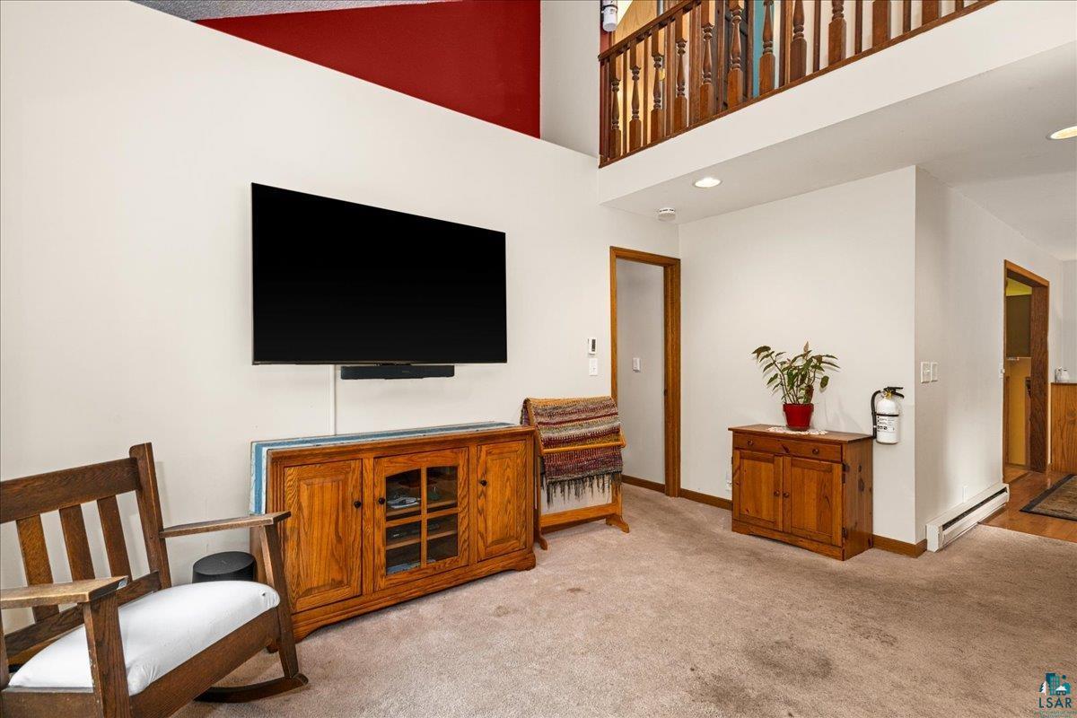 5195 Lavaque Junction Road Hermantown, MN 55811 - Photo 20 of 66 Spacious living area featuring a vaulted ceiling with an accent wall, hardwood railing, and wood-finish door frames