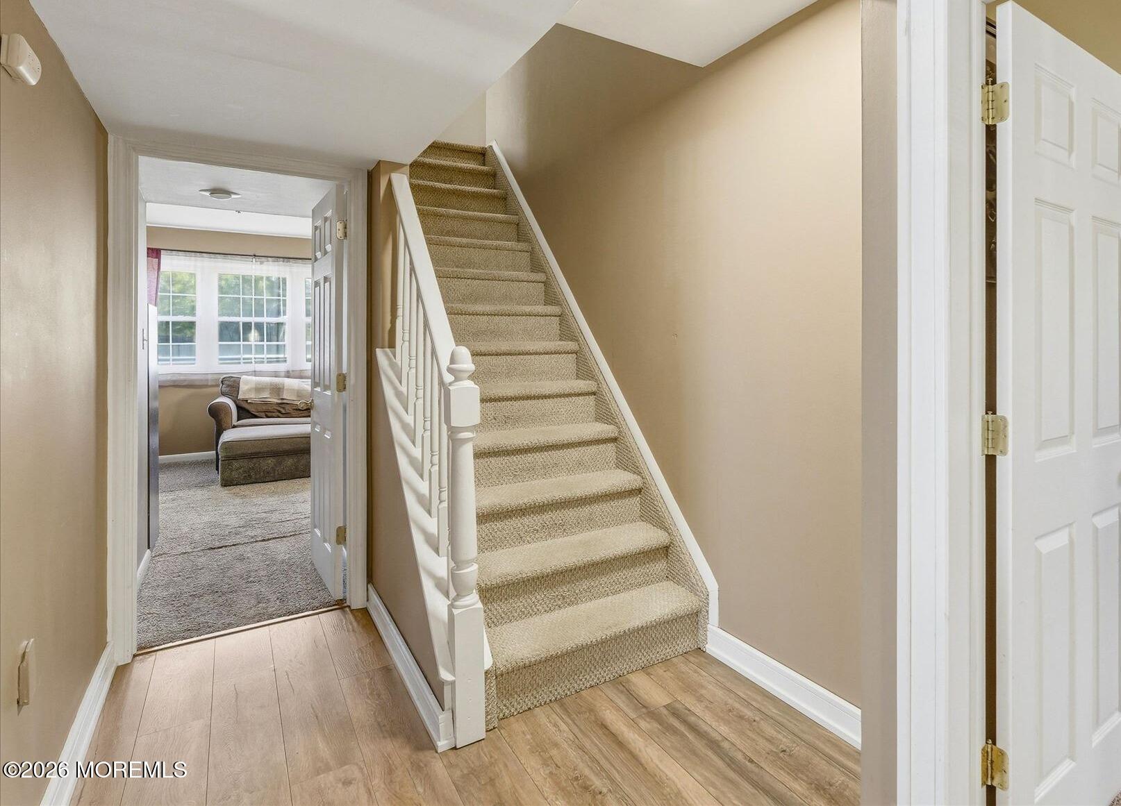 22 Ethan Allen Road Freehold, NJ 07728 - Photo 18 of 31 a view of a hallway to a livingroom with wooden floor and stairs