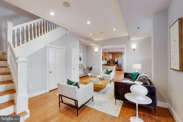 a living room with furniture and a wooden floor