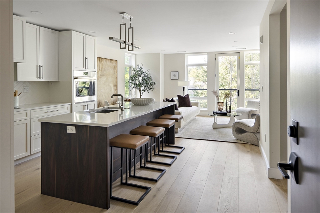 a living room with furniture a large window a table and chairs