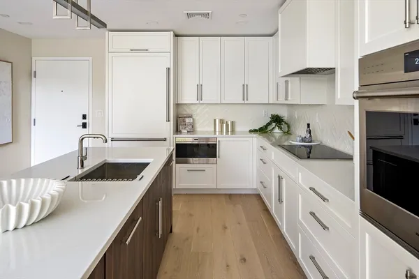 a kitchen with granite countertop a sink stove and cabinets