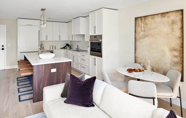 a living room with stainless steel appliances furniture a dining table and chairs