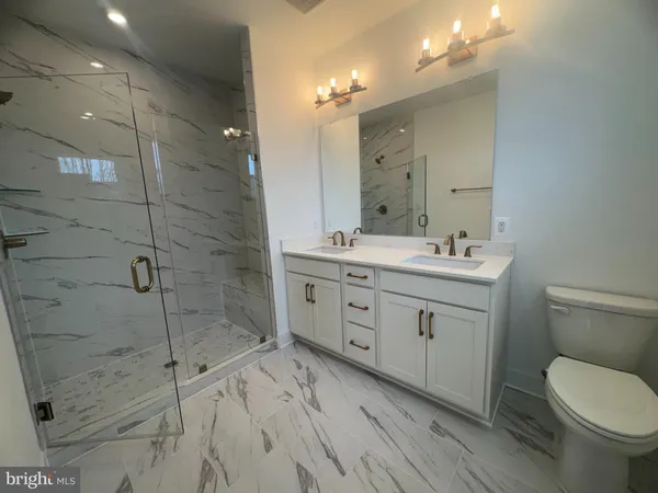 a spacious bathroom with a double vanity sink toilet and shower