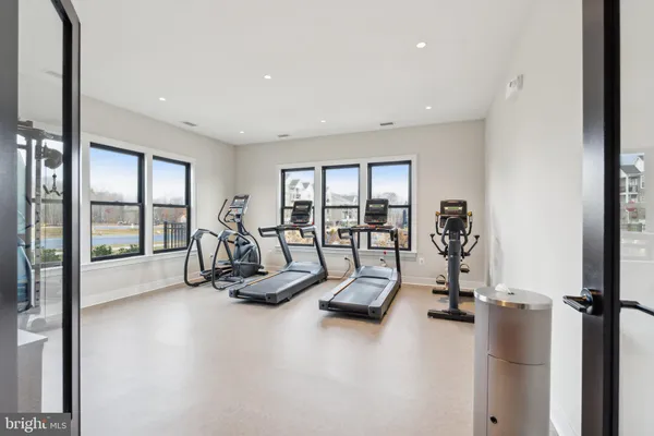 a living room with furniture gym equipment and a large window