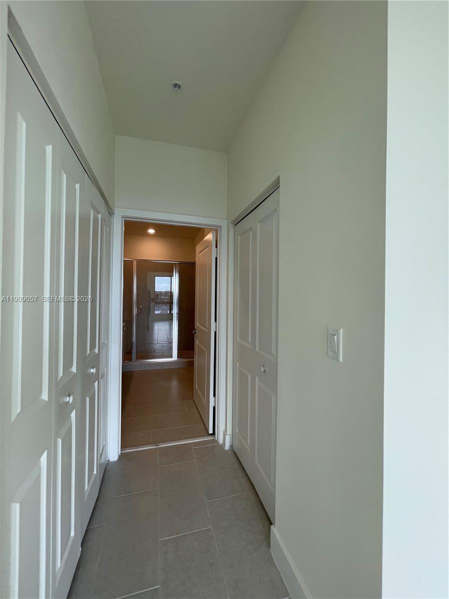 8167 Northwest 41st Street, Unit E409 Doral, FL 33166 - Photo 12 of 30 a view of a hallway with wooden shelves