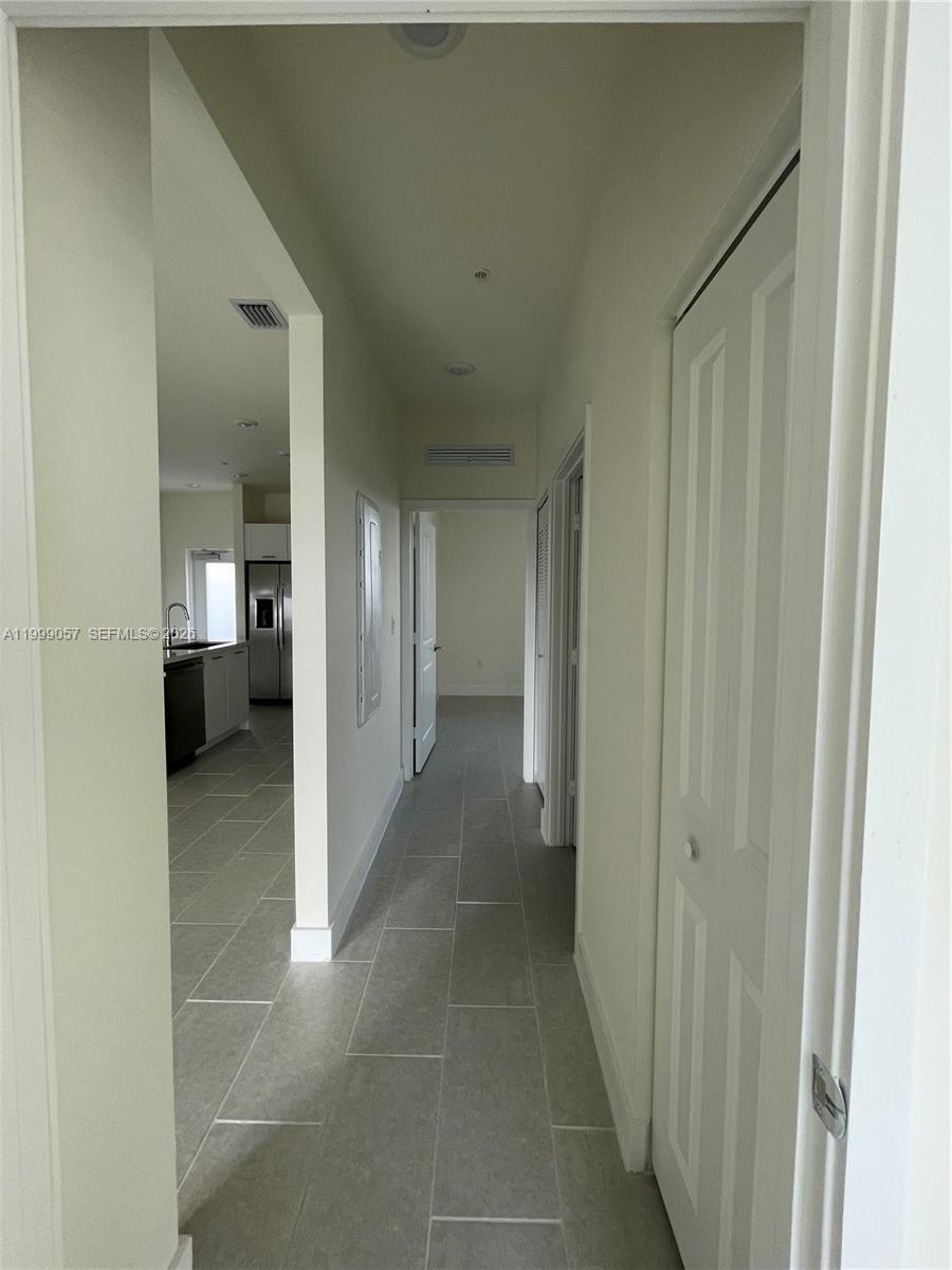 8167 Northwest 41st Street, Unit E409 Doral, FL 33166 - Photo 17 of 30 a view of a hallway with wooden shelves