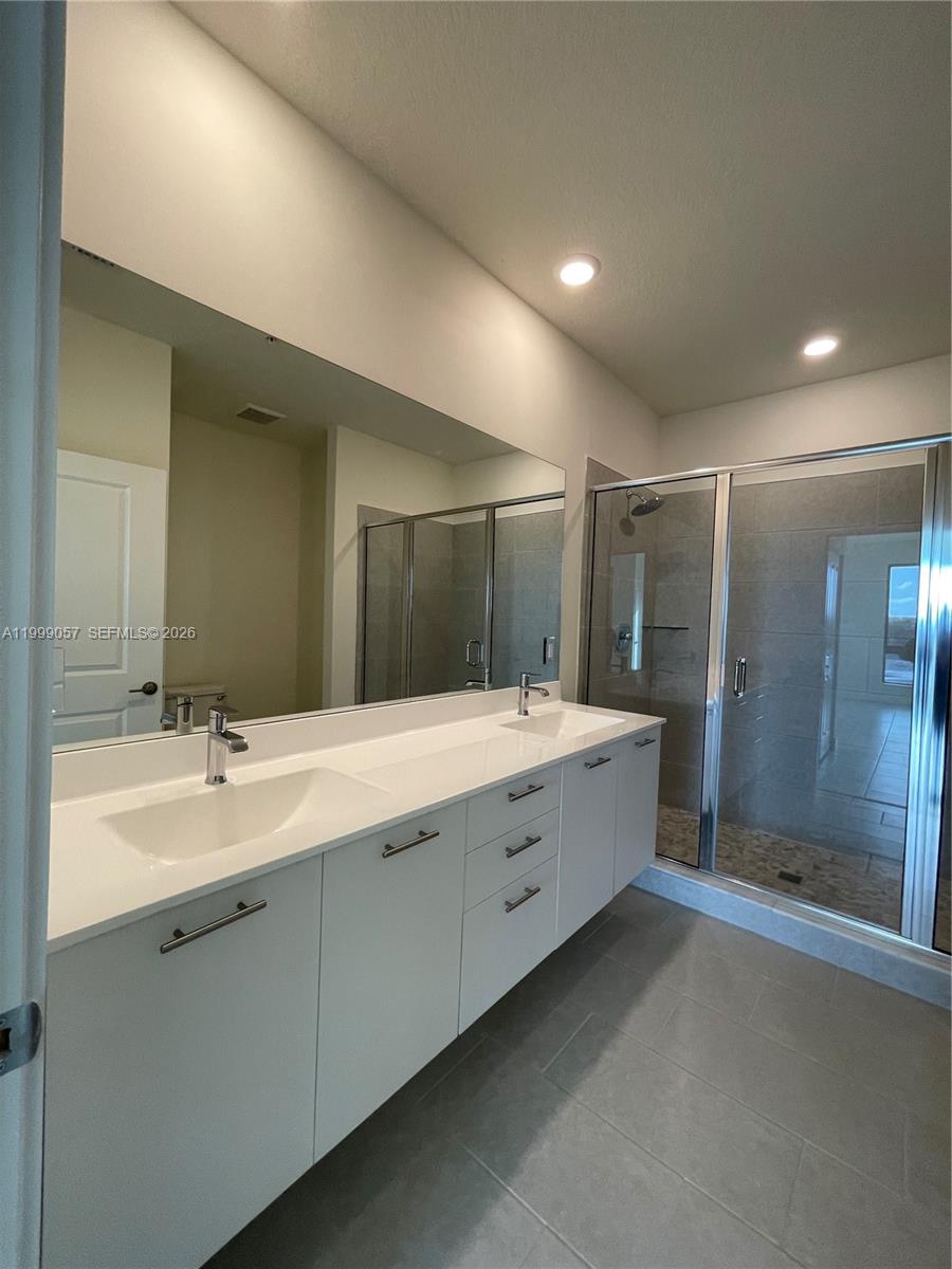 8167 Northwest 41st Street, Unit E409 Doral, FL 33166 - Photo 19 of 30 a spacious bathroom with a mirror a double vanity sink and shower