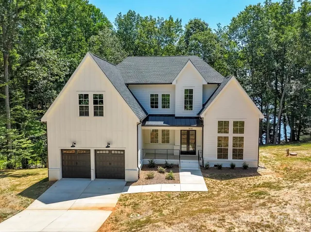 a front view of a house with a yard outdoor seating and garage