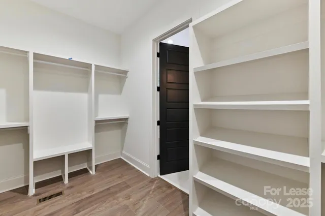 a view of walk in closet with empty racks