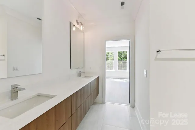 a bathroom with a double vanity sink a mirror and a bathtub