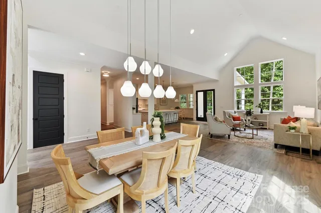 a dining room with wooden floor a chandelier a glass table and chairs