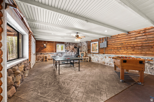 4725 Pine Ridge Road Evanston, UT 82930 - Photo 22 of 82 Spacious room featuring wood plank walls, stone accents, and a durable stamped concrete floor