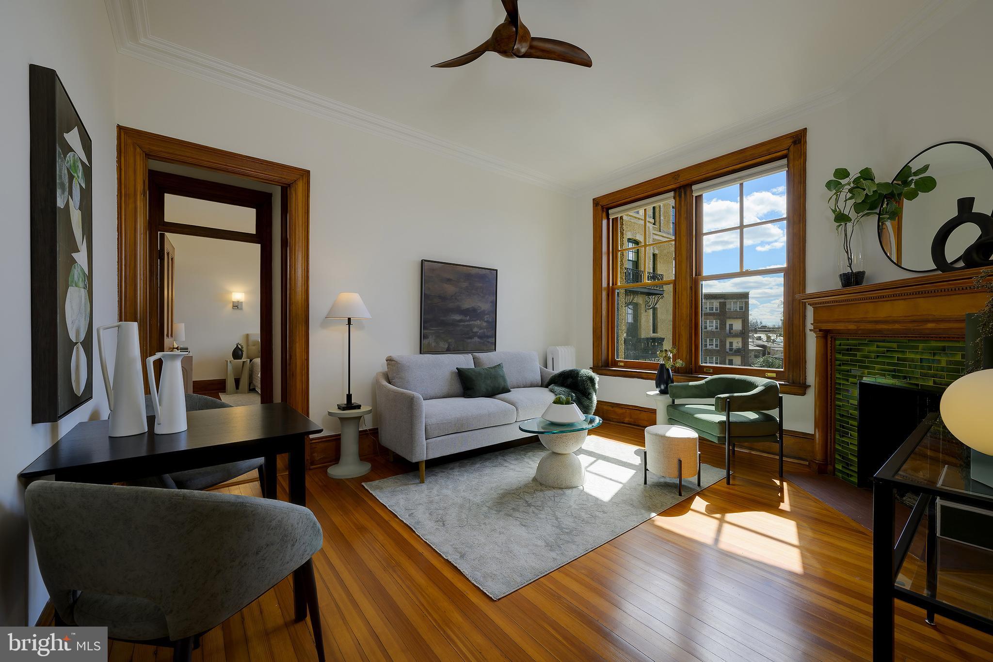 a living room with fireplace furniture and a large window