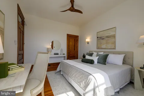 a bedroom with a bed large window and wall painting
