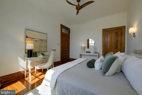 a bedroom with a bed and wooden floor