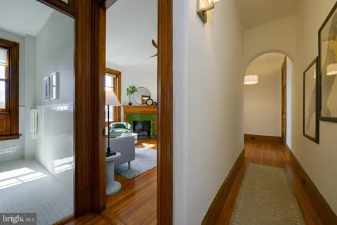 a view of hallway with livingroom and wooden floor