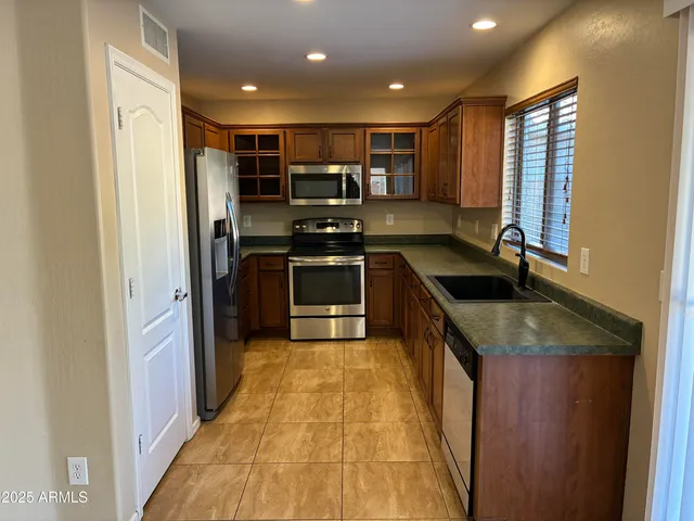 a kitchen with stainless steel appliances granite countertop a sink stove and refrigerator