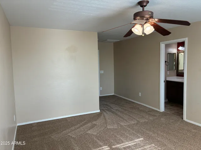 an empty room with a chandelier fan and closet