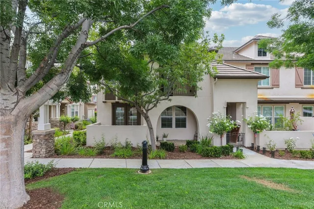 a front view of a house with a yard and trees