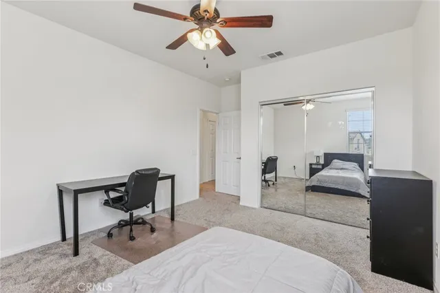 a view of a livingroom with wooden floor and a ceiling fan
