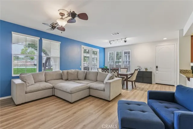 a living room with furniture ceiling fan and a window