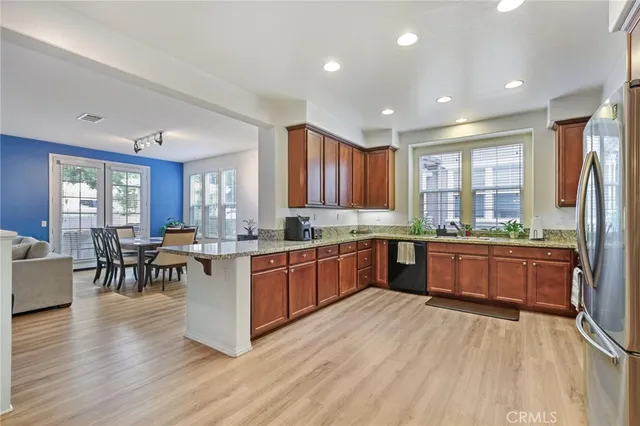 a kitchen with stainless steel appliances granite countertop wooden floors and white cabinets
