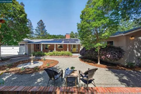 a view of a house with backyard and sitting area