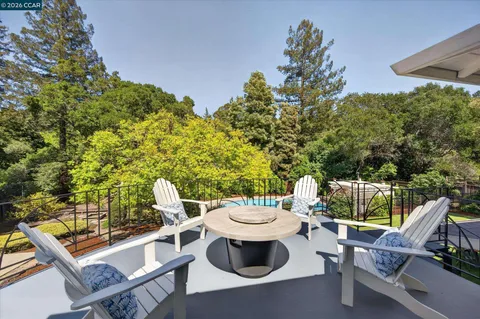 a view of a patio with table and chairs potted plants with large tree