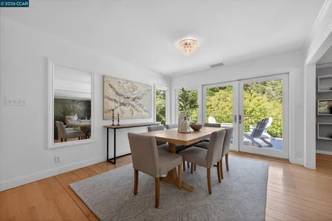 a dining room with furniture a rug and a floor to ceiling window