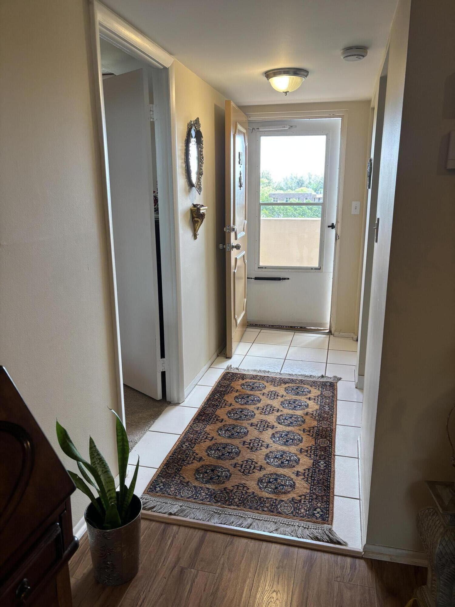6461 Northwest 2nd Avenue, Unit 5 Boca Raton, FL 33487 - Photo 4 of 11 a view of a hallway with wooden floor and a livingroom