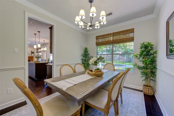 a living room with furniture kitchen view and a wooden floor