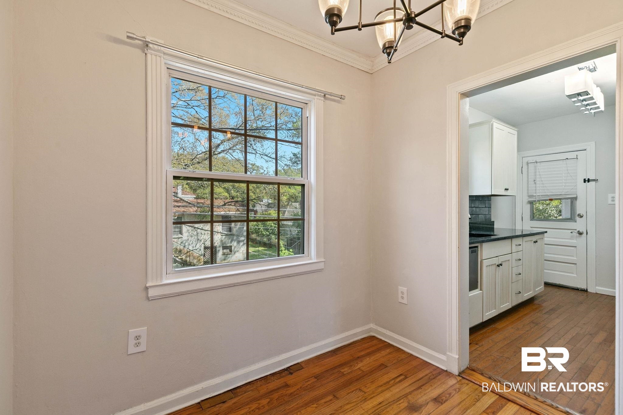 214 Upham Street, Unit 8D Mobile, AL 36607 - Photo 18 of 36 Unfurnished dining area featuring dark wood-style flooring, hanging lights, and ornamental molding