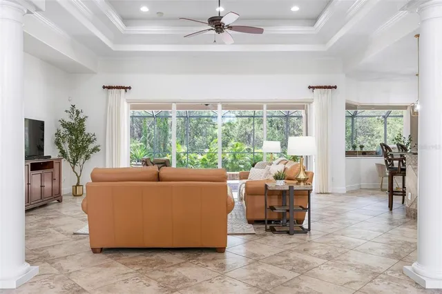 a living room with furniture kitchen view and a chandelier