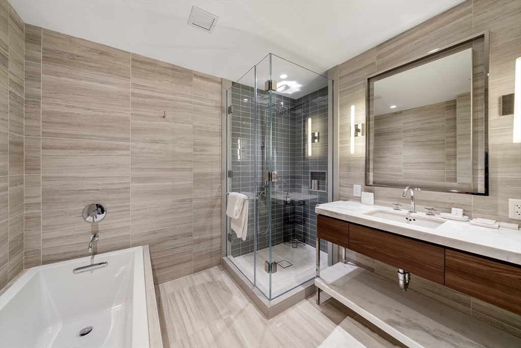 40 Trinity Place, Unit 1518 Boston, MA 02116 - Photo 8 of 25 a bathroom with a tub sink and mirror