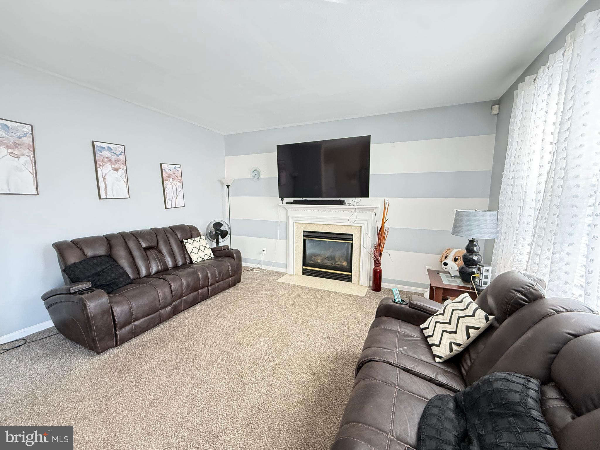 215 Seamaster Road Essex, MD 21221 - Photo 13 of 34 a living room with furniture a fireplace and a flat screen tv