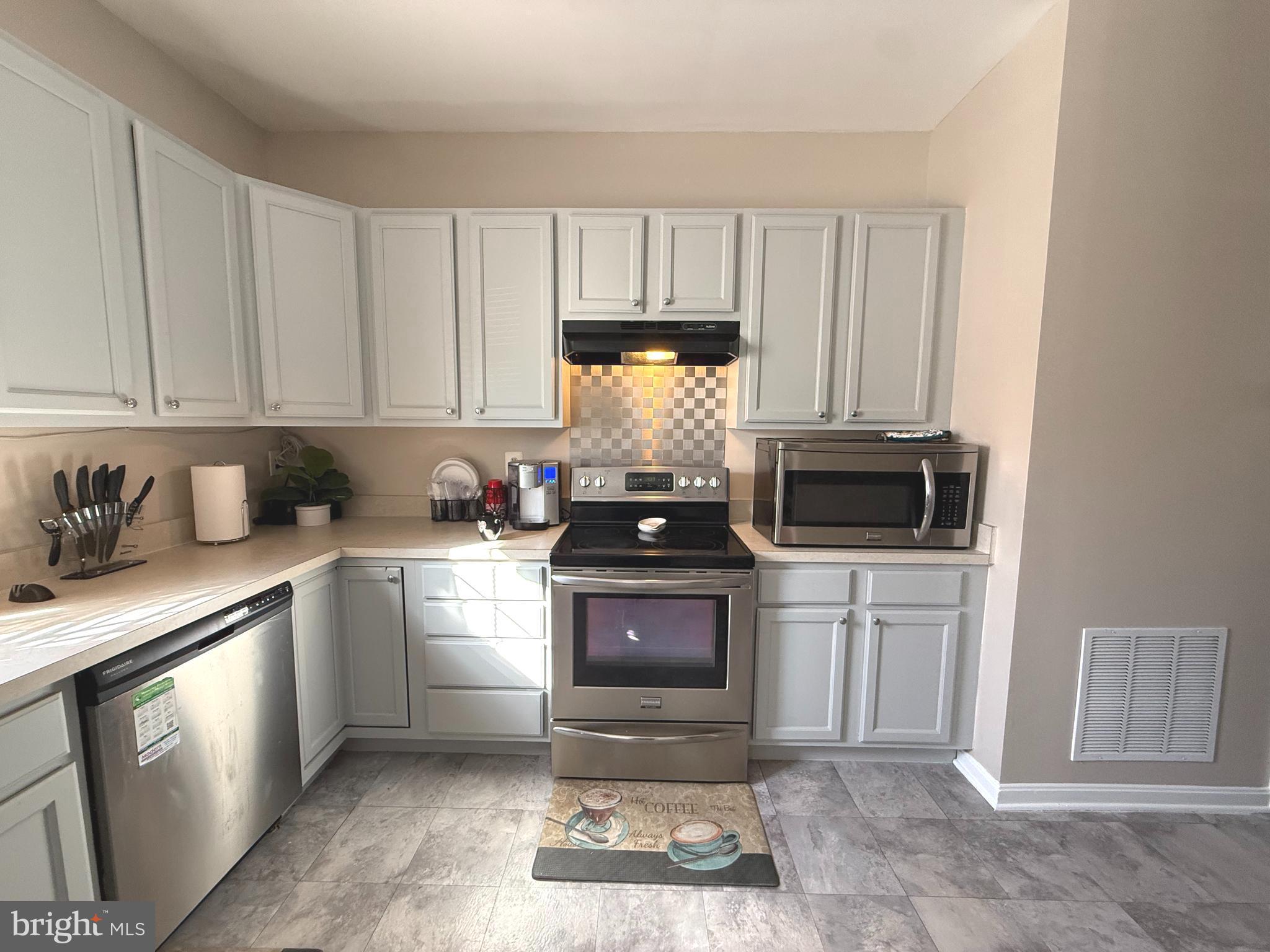 215 Seamaster Road Essex, MD 21221 - Photo 3 of 34 a kitchen with a stove and white cabinets