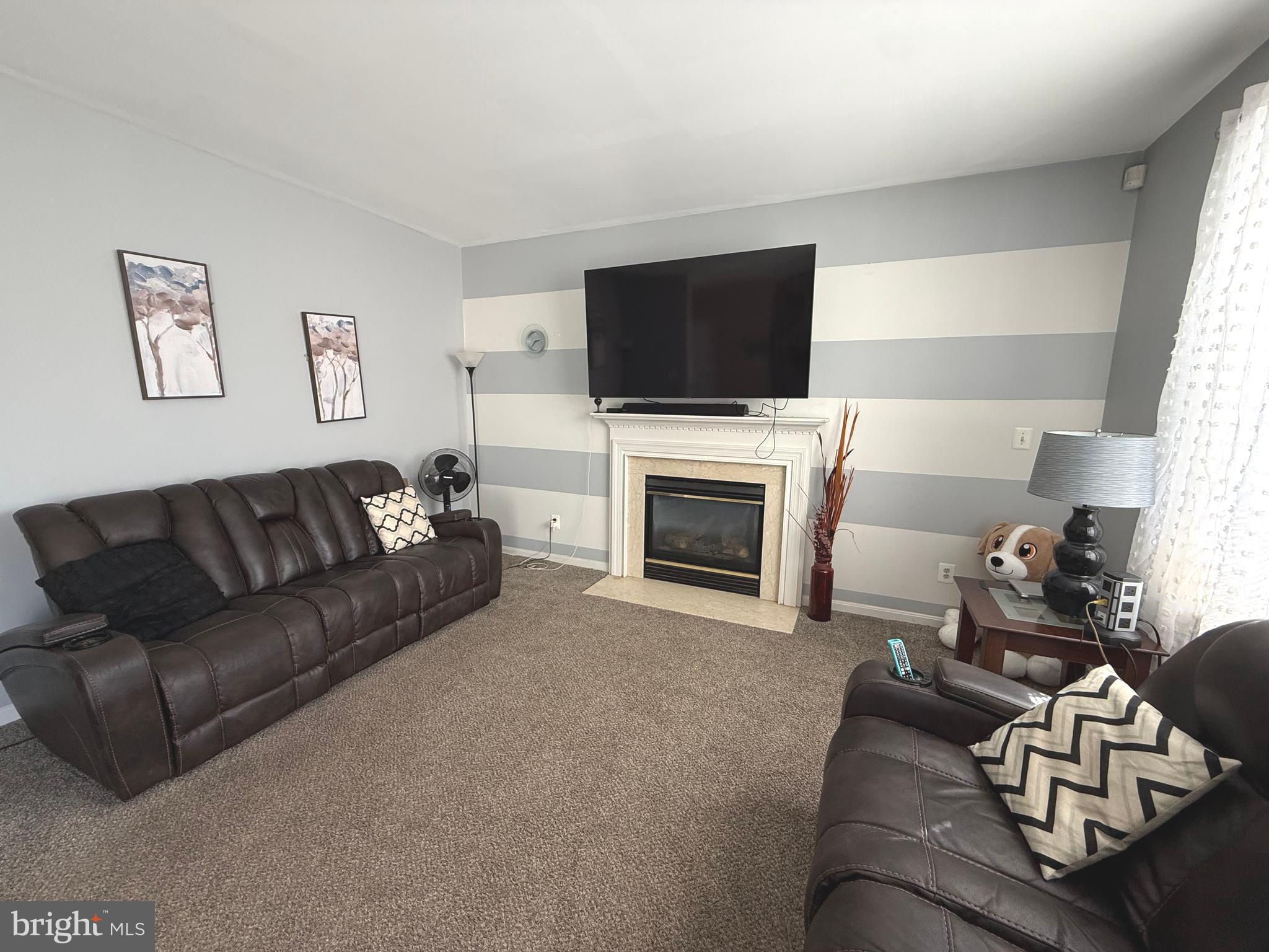 215 Seamaster Road Essex, MD 21221 - Photo 7 of 34 a living room with furniture a flat screen tv and a fireplace