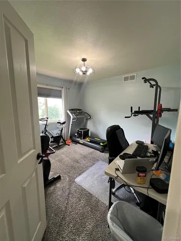 a view of a workspace with furniture and a window