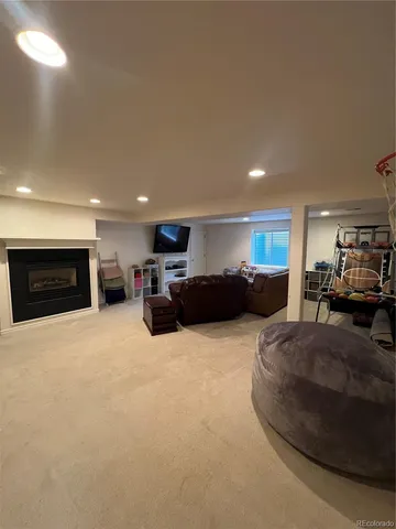 a large bedroom with furniture a fireplace and a flat tv screen
